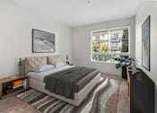 Thumbnail 6 of 15 - a bedroom with a bed and a large window