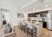 Thumbnail 4 of 24 - A modern kitchen with a dining table and chairs.