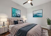 Thumbnail 7 of 27 - A bedroom with a bed, two lamps, a ceiling fan, and two pictures on the wall.