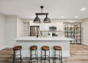 Thumbnail 15 of 19 - a kitchen with a large island with four stools in front of a kitchen counter
