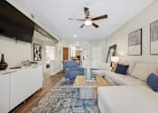 Thumbnail 4 of 21 - A living room with a white couch and a blue rug.