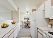 Thumbnail 2 of 22 - A kitchen with white appliances and a table with chairs.
