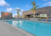 Thumbnail 2 of 31 - A large outdoor swimming pool with a screen and loungers.
