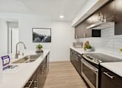 Thumbnail 3 of 24 - A modern kitchen with a stainless steel oven and a white countertop.