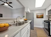 Thumbnail 1 of 27 - A kitchen with a bowl of oranges on the counter.