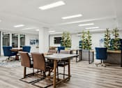 Thumbnail 17 of 19 - a conference room with tables and chairs and plants in the middle