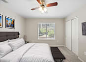 Thumbnail 24 of 29 - A bedroom with a large bed and a ceiling fan.