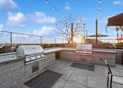 Thumbnail 24 of 31 - A rooftop patio with a grill and a table.