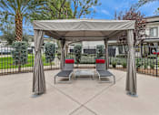 Thumbnail 12 of 17 - A patio with a canopy and two chairs.
