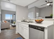 Thumbnail 2 of 27 - A modern kitchen with a large island and a bowl of fruit on the counter.