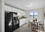 Thumbnail 1 of 10 - an apartment kitchen with black appliances and a table and chairs