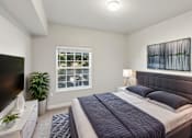 Thumbnail 5 of 20 - A bedroom with a large bed and a television.