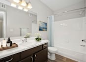 Thumbnail 18 of 33 - A bathroom with a white sink and a white toilet.