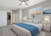 Thumbnail 6 of 27 - A bedroom with a large bed and a ceiling fan.