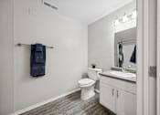 Thumbnail 20 of 29 - A bathroom with a toilet, sink, and a mirror.