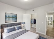 Thumbnail 6 of 20 - A bedroom with a large bed and a painting on the wall.
