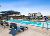 Thumbnail 18 of 37 - a swimming pool with chairs and umbrellas at the resort on a sunny day