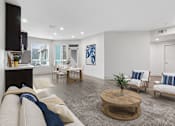 Thumbnail 3 of 15 - A living room with a white couch and a coffee table.