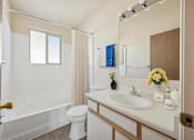 Thumbnail 7 of 22 - A white bathroom with a toilet, sink, and bathtub.