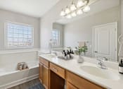 Thumbnail 10 of 23 - a bathroom with a sink and a tub and a mirror