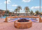 Thumbnail 17 of 38 - A fire pit in the middle of a patio surrounded by a brick wall.