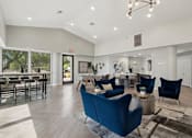 Thumbnail 16 of 24 - A spacious living room with blue chairs and a dining table.