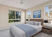 Thumbnail 3 of 25 - A bedroom with a large bed and a ceiling fan.