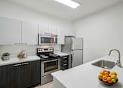 Thumbnail 2 of 27 - A kitchen with a stove, oven, refrigerator, and sink.