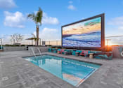 Thumbnail 17 of 31 - A large screen TV is mounted on a wall above a swimming pool.