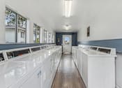 Thumbnail 17 of 17 - A laundromat with rows of washers and dryers.