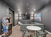 Thumbnail 16 of 20 - a gaming room with a table and chairs and a television