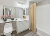 Thumbnail 4 of 20 - A white bathroom with a toilet, sink, and mirror.