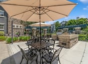 Thumbnail 14 of 23 - a patio with a table and chairs and a fire pit