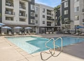 Thumbnail 14 of 28 - a swimming pool in front of an apartment building