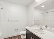 Thumbnail 6 of 31 - A white bathroom with a toilet, sink, and shower.