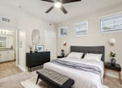 Thumbnail 11 of 28 - A bedroom with a large bed and a ceiling fan.