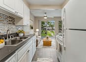 Thumbnail 1 of 17 - A kitchen with white cabinets and a white refrigerator.