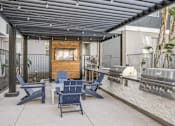 Thumbnail 17 of 28 - an outdoor patio with blue chairs and a grill and a tv