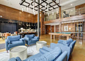 Thumbnail 22 of 42 - A modern living room with blue couches and a pool table.