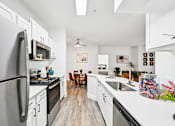 Thumbnail 2 of 34 - A kitchen with black appliances and white cabinets.