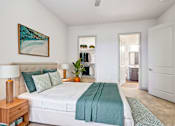 Thumbnail 24 of 24 - A bedroom with a large bed and a painting on the wall.