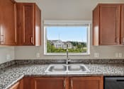 Thumbnail 5 of 27 - A kitchen with a double sink and wooden cabinets.