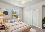Thumbnail 9 of 30 - A bedroom with a large bed and a ceiling fan.