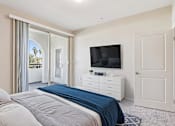 Thumbnail 5 of 25 - A bedroom with a bed, dresser, and television.