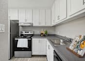 Thumbnail 3 of 21 - a white kitchen with stainless steel appliances and white cabinets