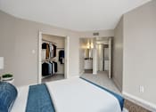 Thumbnail 7 of 26 - a bedroom with a large bed and a closet with clothes racks