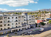 Thumbnail 24 of 24 - A street view of a residential area with apartment buildings and cars.