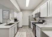 Thumbnail 1 of 18 - a spacious kitchen with white cabinets and stainless steel appliances
