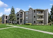 Thumbnail 19 of 20 - an apartment building with a green lawn and sidewalk