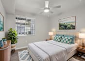 Thumbnail 9 of 28 - A bedroom with a large bed and a ceiling fan.